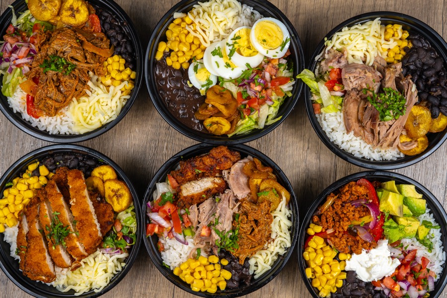 Seis bowls de arroz con pollo, carne y vegetales vistos desde arriba