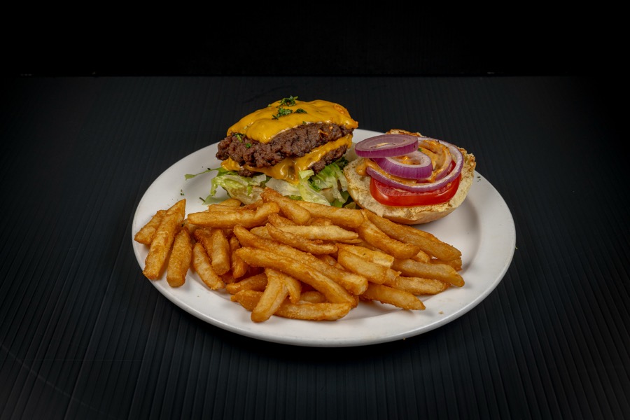 Hamburguesa con papas sobre fondo oscuro