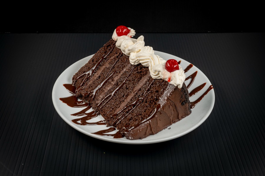 Porción de torta de chocolate con crema y una cereza