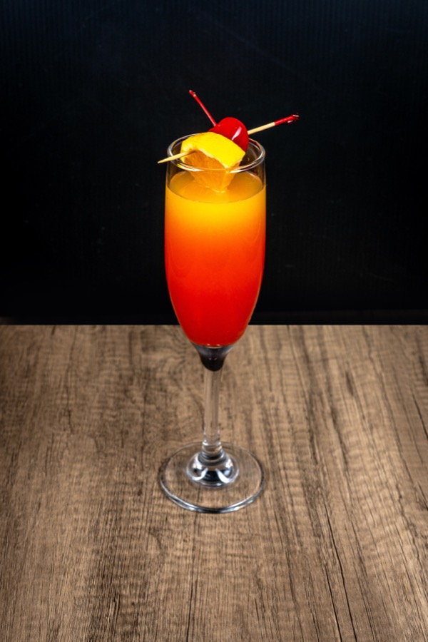 Cóctel rojo y naranja en una copa alta